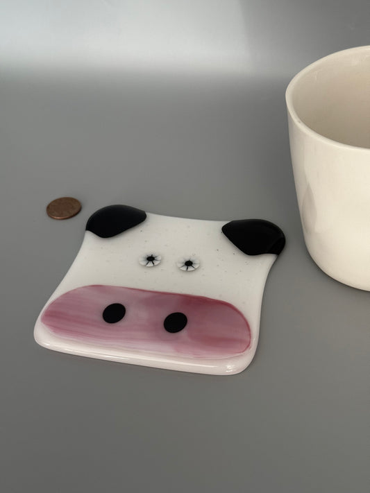 Decorative ceramic dog bowl with black and pink details on a gray background.