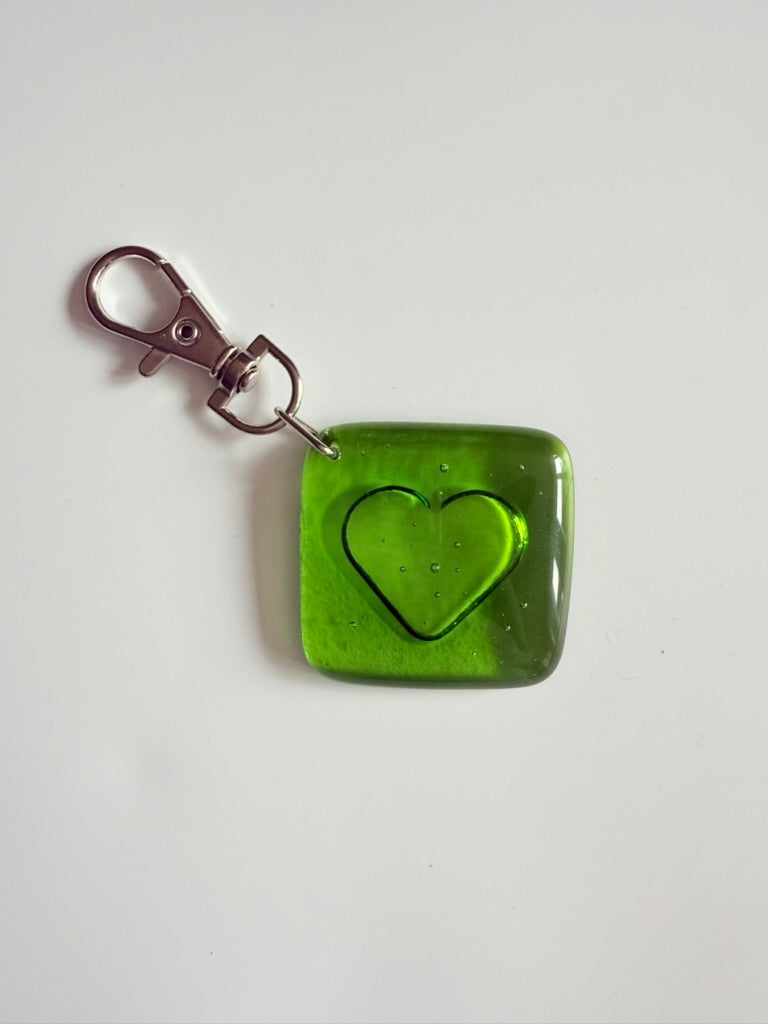 Green square keychain with a heart design 