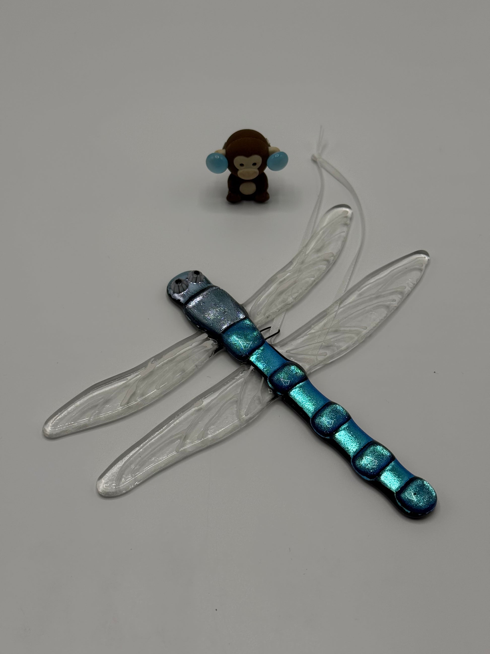 Dragonfly toy with blue and black body on a gray background